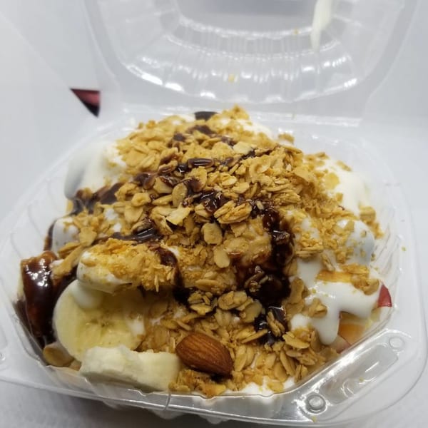 Garrafa's fruit and yogurt parfait with granola, chocolate syrup, banana slices, and an almond.