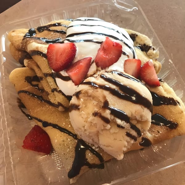 Garrafa's dessert crepes with vanilla ice cream, whipped cream, strawberries, and chocolate drizzle.